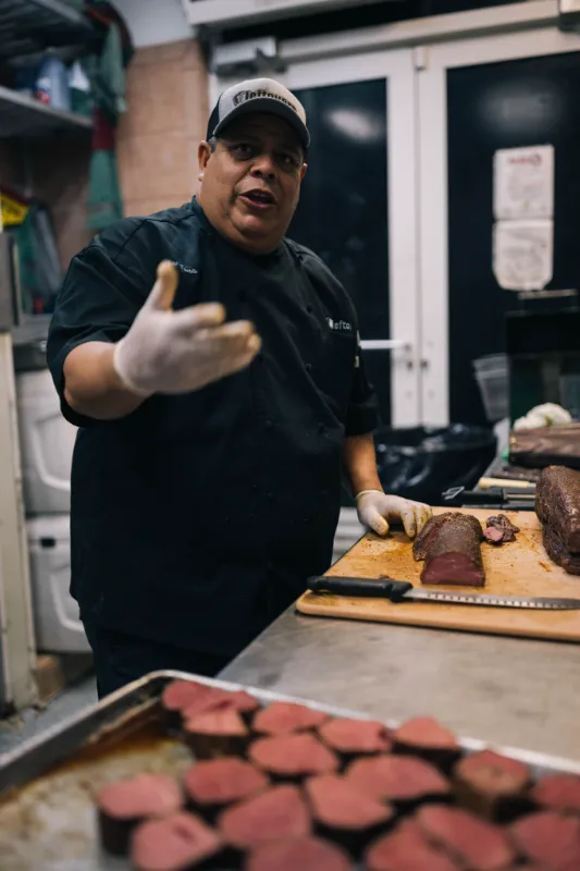Chef busy cutting food in the kitchen of Leftovers Restaurant